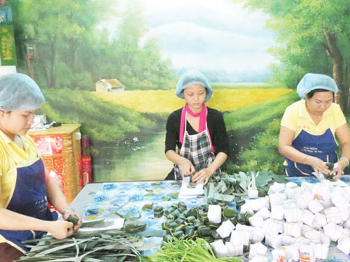 Ba người làm tré tại cơ sở Thanh Bình, bên bàn có lá, gói tré và giấy bọc