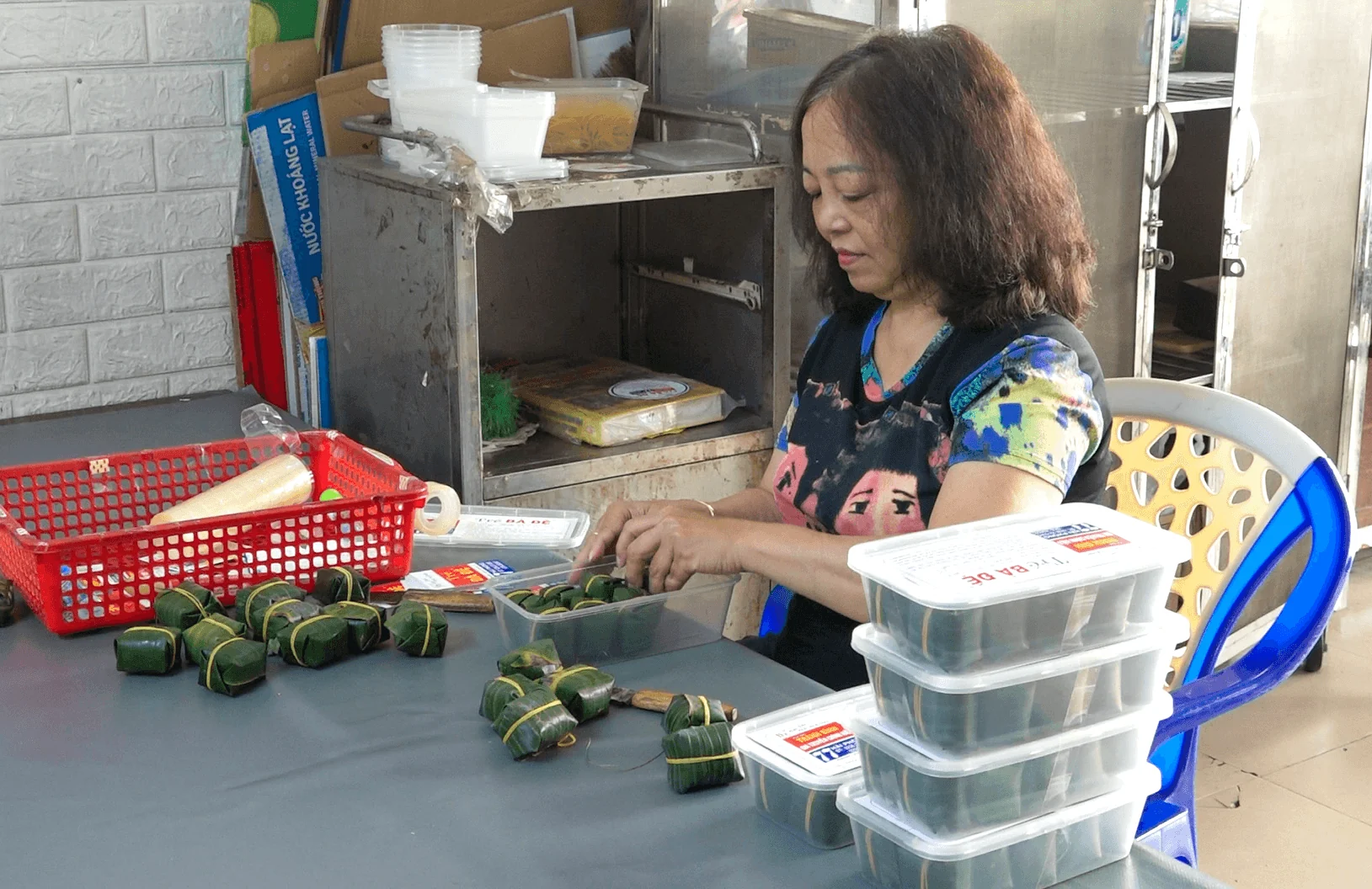 Bà Mai Thị Thanh Bình ngồi bên bàn, xếp những gói tré bọc lá vào hộp